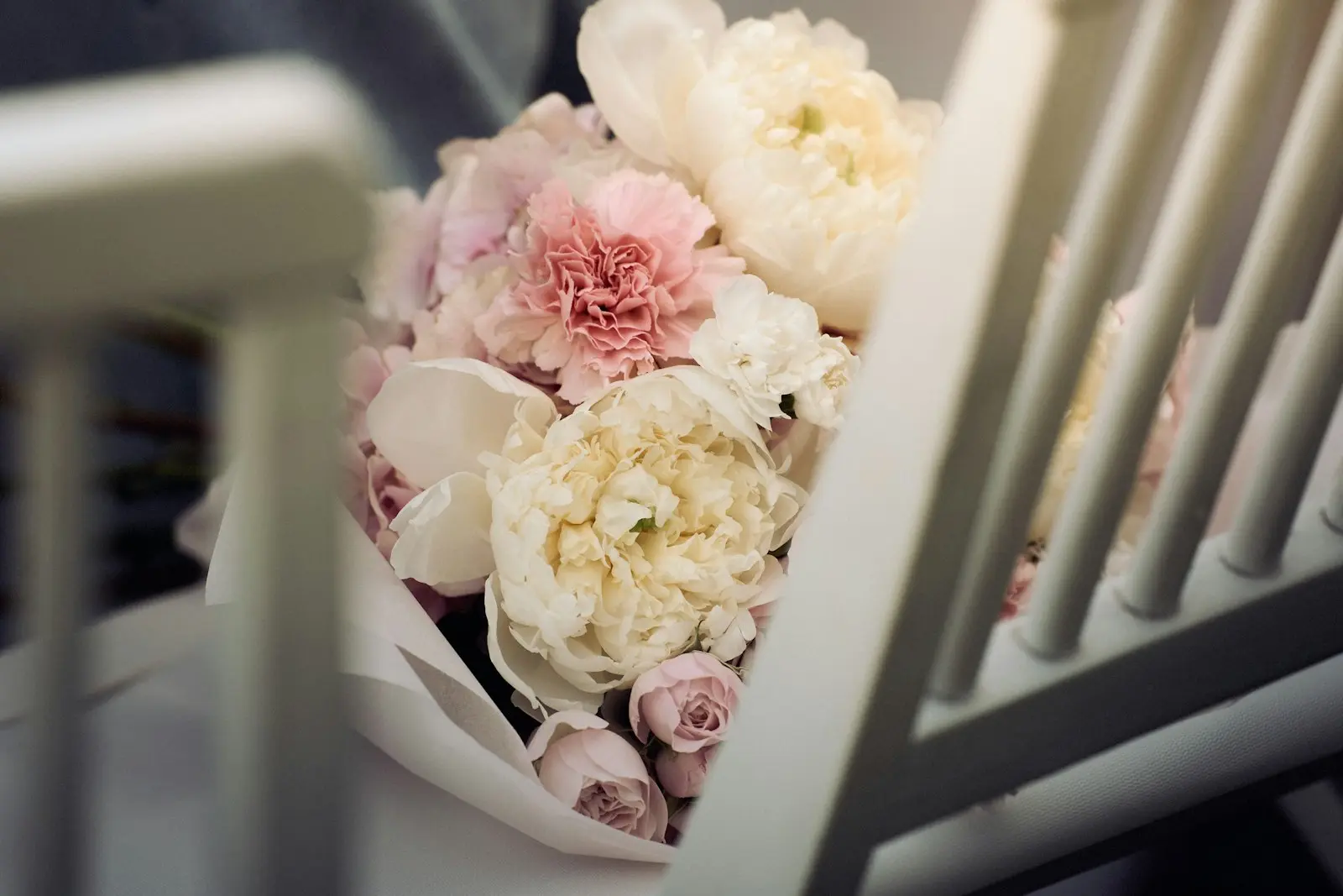 Bouquet de pivoines roses et blanches emballé dans du papier